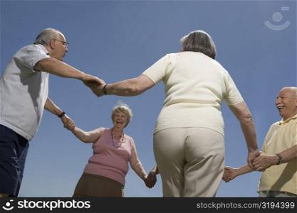 Low angle view of senior people holding hands of each other