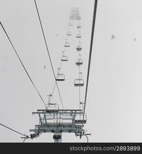 Low angle view of skiers on ski lifts, Symphony Amphitheatre, Whistler, British Columbia, Canada