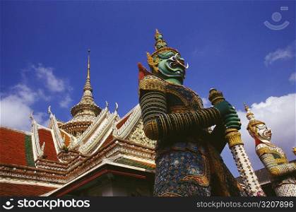 Low angle view of statues in front of a temple, Wat Arun, Bangkok, Thailand