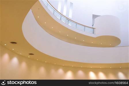 Low angle view of stunning curve line pattern of interior spiral staircase with lighting inside of Bangkok art and culture centre at Bangkok, Thailand
