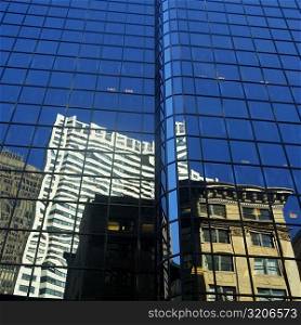 Low angle view of the reflection of buildings on a glass front, Boston, Massachusetts, USA