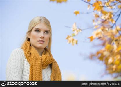 Low angle view of thoughtful young woman against sky