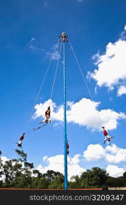 Low angle view of totonac voladores flying dancers flying from the pole, El Tajin, Veracruz, Mexico