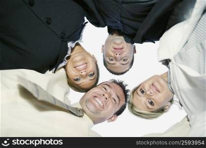 Low angle view of two businessmen and two businesswomen in a huddle