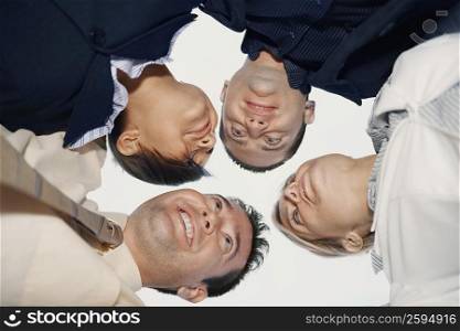 Low angle view of two businessmen and two businesswomen in a huddle