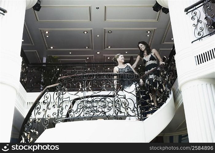 Low angle view of two mid adult women standing at the balcony of a ship