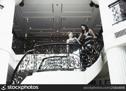 Low angle view of two mid adult women standing at the balcony of a ship