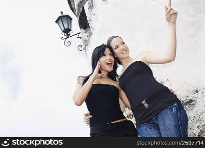 Low angle view of two young women looking sideways