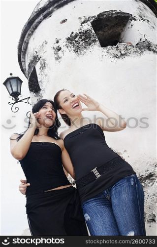 Low angle view of two young women shouting