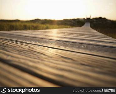 Low angle view of wooden boardwalk leading to beach at Bald Head Island, North Carolina.