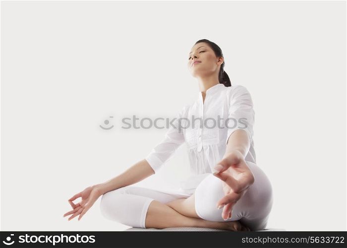 Low angle view of young woman sitting in lotus position