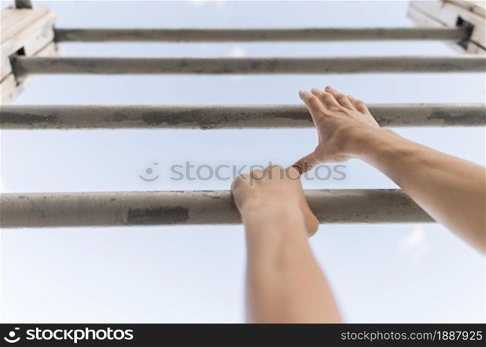 low angle woman climbing metal bars . Resolution and high quality beautiful photo. low angle woman climbing metal bars . High quality and resolution beautiful photo concept