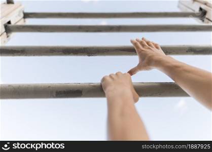low angle woman climbing metal bars . Resolution and high quality beautiful photo. low angle woman climbing metal bars . High quality and resolution beautiful photo concept