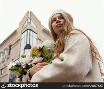 low angle woman outdoors holding bouquet flowers spring