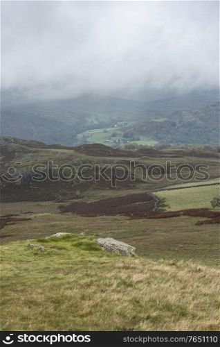 Low cloud hanging over Lake District landscape giving a moody image looking into the distant hills and mountains