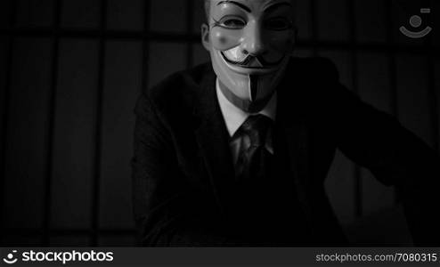 low dolly shot of Anonymous hacker in prison (B/W Version)