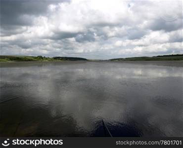 low heavy clouds over lake. forest in the background. landscape with low clouds