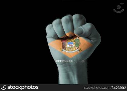 Low key picture of a fist painted in colors of american state flag of delaware