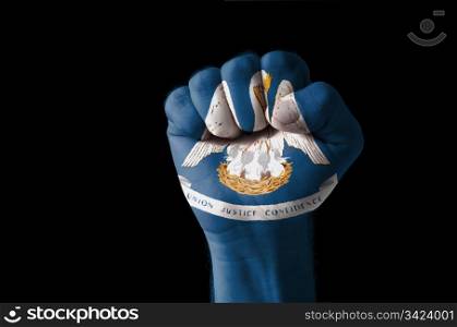 Low key picture of a fist painted in colors of american state flag of louisiana