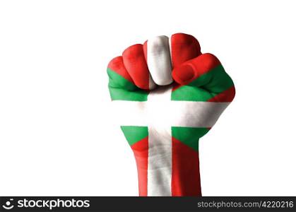 Low key picture of a fist painted in colors of basque flag