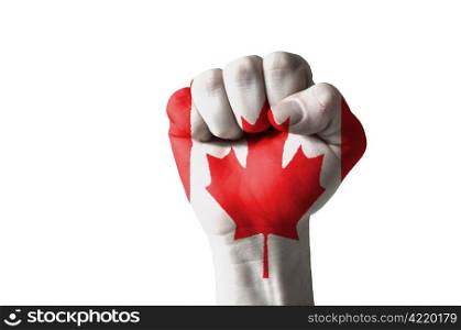 Low key picture of a fist painted in colors of canada flag