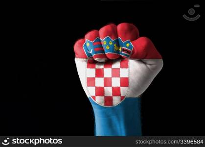 Low key picture of a fist painted in colors of croatia flag