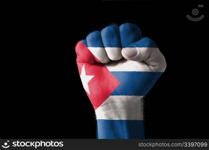 Low key picture of a fist painted in colors of cuba flag