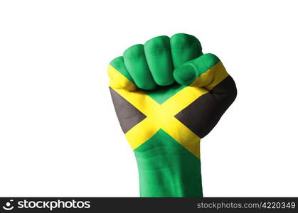 Low key picture of a fist painted in colors of jamaica flag