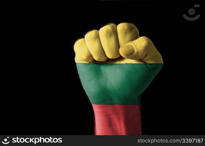 Low key picture of a fist painted in colors of lithuania flag