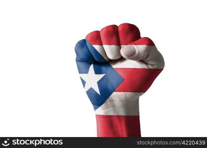 Low key picture of a fist painted in colors of puertorico flag