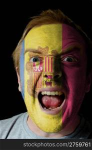 Low key portrait of an angry man whose face is painted in colors of andoran flag