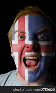 Low key portrait of an angry man whose face is painted in colors of iceland flag