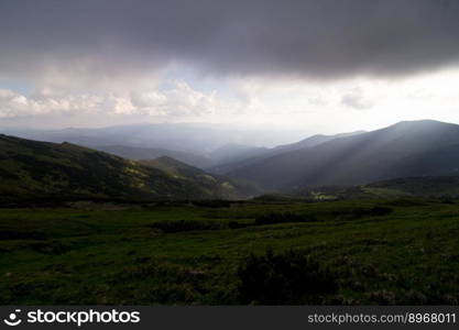 Low lying rain clouds above hill landscape photo. Beautiful nature scenery photography with highlands on background. Ambient light. High quality picture for wallpaper, travel blog, magazine, article. Low lying rain clouds above hill landscape photo