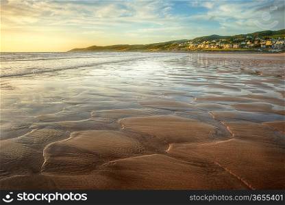 Low point of view along beach at sunset with excellent detail in sand texture