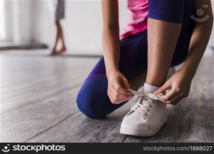 low section girl tying shoelace white shoes. Resolution and high quality beautiful photo. low section girl tying shoelace white shoes. High quality and resolution beautiful photo concept