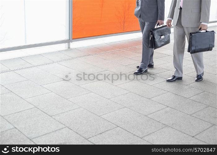 Low section of businessmen with briefcase walking in railroad station