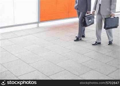 Low section of businessmen with briefcase walking in railroad station