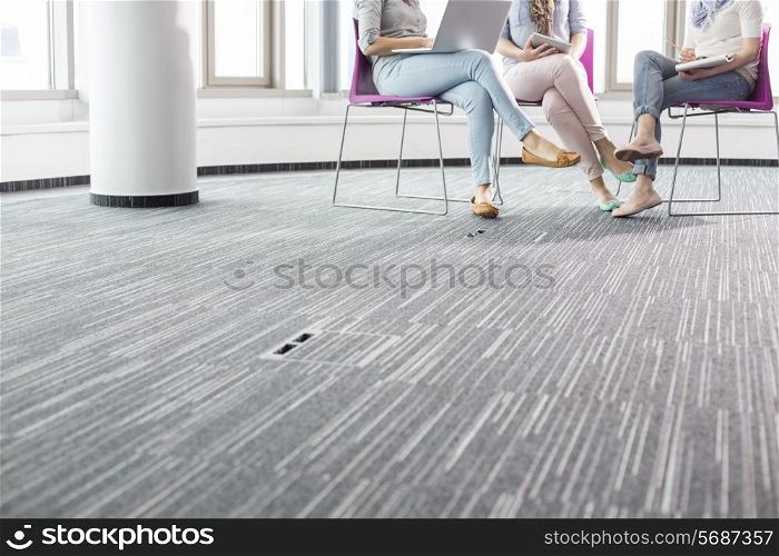 Low section of businesswomen working in creative office