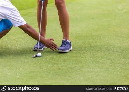 Low section of female golf player ready to hit the ball