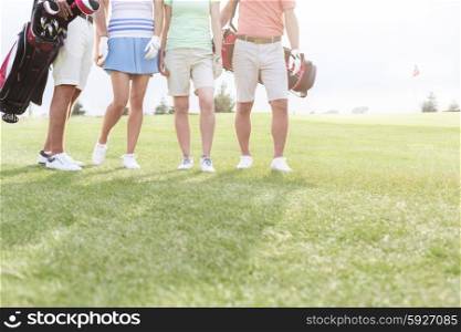 Low section of friends standing at golf course