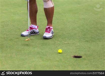Low section of male golf player ready to hit the ball