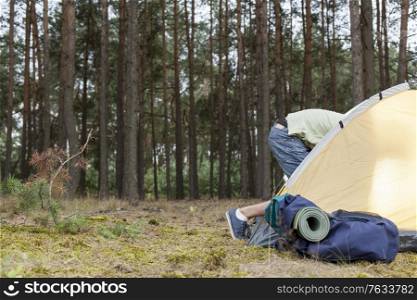 Low section of man entering tent in forest