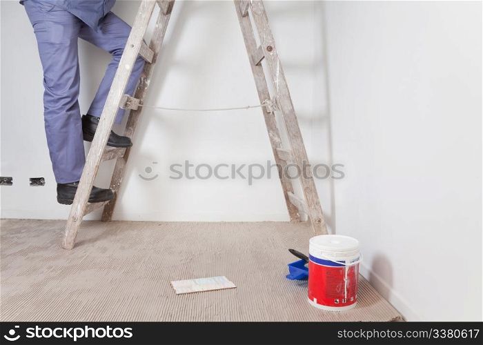 Low section of man&rsquo;s legs climbing wooden ladder