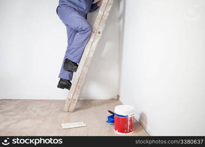 Low section of man&rsquo;s legs climbing wooden ladder