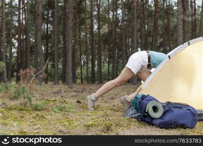 Low section of woman entering tent in forest