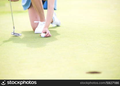 Low section of woman placing ball at golf course