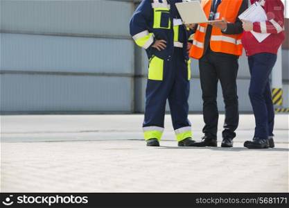 Low section of workers discussing in shipping yard