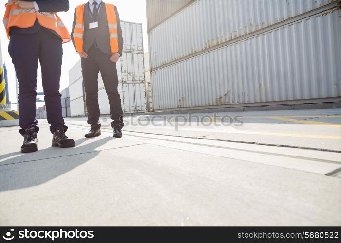 Low section of workers standing in shipping yard