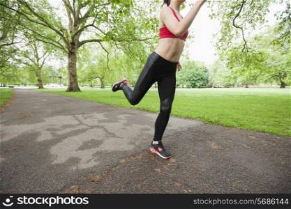 Low section of young woman jogging in park