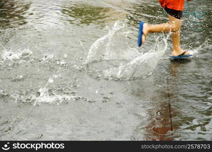 Low section view of a boy splashing water